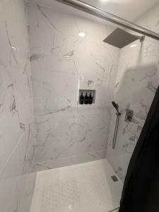 La salle de bains est pourvue d'une douche et de murs en marbre blanc. dans l'établissement cozy casa colorado, à Las Vegas