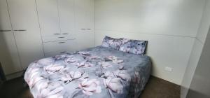 een slaapkamer met een bed met roze bloemen erop bij Misty Valley Hilltop Farmstay - Off Grid Retreat in Otorohanga