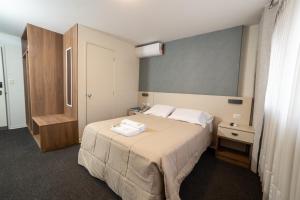 Un dormitorio con una cama y un armario de madera. en VIP Hotel, en Ilo