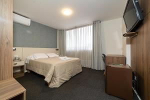 una habitación de hotel con cama y televisor de pantalla plana en VIP Hotel, en Ilo