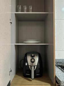 a toaster sitting on a shelf in a kitchen at Studio prático e bem localizado em Cuiabá in Cuiabá