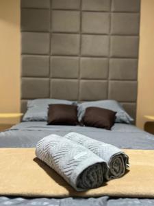 a bed with two towels sitting on top of it at Studio prático e bem localizado em Cuiabá in Cuiabá