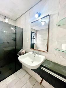 Un baño blanco con lavabo y ducha. en Sky pool São Vicente, en São Vicente