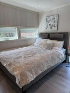 ein großes Bett in einem Schlafzimmer mit zwei Fenstern in der Unterkunft Modern cottage in Skibotn in Fossmo + 35 Fotos