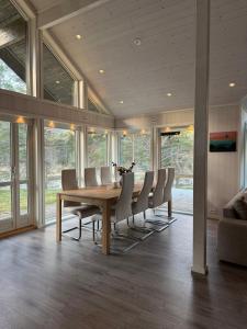 ein Esszimmer mit einem langen Tisch und Stühlen in der Unterkunft Modern cottage in Skibotn in Fossmo