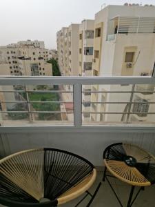- deux chaises sur un balcon avec vue sur les bâtiments dans l'établissement Premium Luxury Family Home in Downtown Meknes, à Meknès