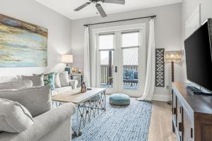 a living room with a couch and a tv at Redfish Village - Beach-a-holic - M1-313 in Santa Rosa Beach