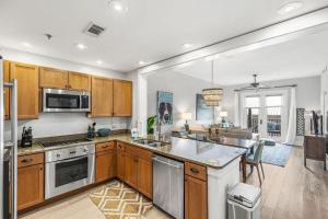 a kitchen with wooden cabinets and stainless steel appliances at Redfish Village - Beach-a-holic - M1-313 in Santa Rosa Beach