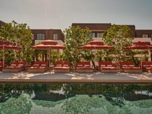 a hotel pool with chairs and umbrellas and a building at The EVE Hotel Sydney in Sydney
