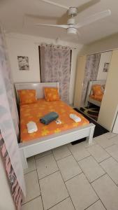 ein Bett mit orangefarbenen Laken und Kissen in einem Zimmer in der Unterkunft La maison des flots in Baille-Argent