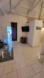 ein Wohnzimmer mit einem TV und Fliesenboden in der Unterkunft La maison des flots in Baille-Argent