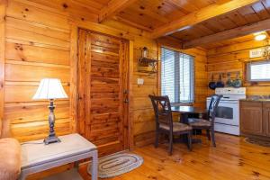 a dining room with a table and a kitchen in a cabin at Hillside Loft with Hot Tub Red River in Campton +25 photos