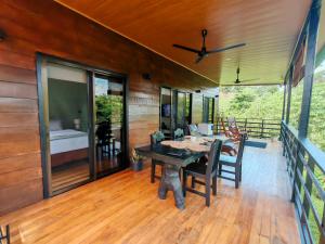 a dining room with a table and chairs on a deck at Ceibo Lodge in Bijagual