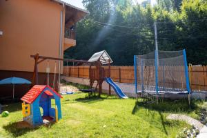 a backyard with a playground with a slide and swings at Pensiunea NikoBella Panzió in Sovata