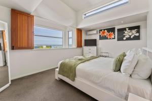 a white bedroom with a bed and a window at Stay Central Taupo in Taupo