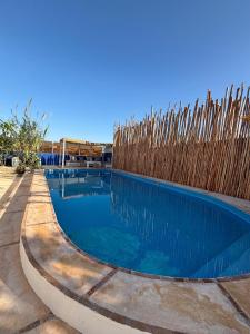 einem Pool vor einem Holzzaun in der Unterkunft Villa Aloe Vera Privée in Essaouira