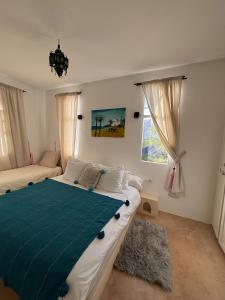 ein Schlafzimmer mit einem großen Bett mit einer blauen Decke in der Unterkunft Villa Aloe Vera Privée in Essaouira
