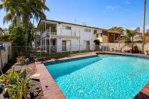 a swimming pool in front of a house at Esplanade 123 Golden Beach in Golden Beach