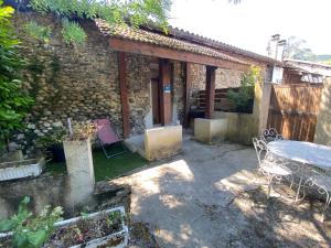 Saint-Just-de-ClaixGîte 2 à 4 personnes au pied du Vercors的建筑物前有桌椅的露台