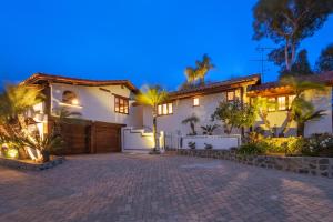 ein großes weißes Haus mit Auffahrt in der Nacht in der Unterkunft North County Oasis Elegant hacienda home with elevated entertainment area & private pool in Vista