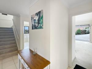 a living room with white walls and a wooden table at Beachside Retreat with Garage Parking in Surf Beach