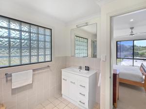 a bathroom with a sink and a mirror at Beachside Retreat with Garage Parking in Surf Beach
