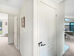 a white door in a hallway with a living room at Beachside Retreat with Garage Parking in Surf Beach