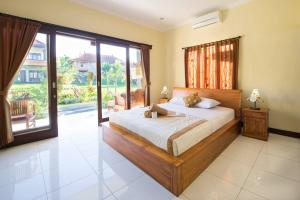 a bedroom with a large bed and a large window at Sari Bungalow in Ubud