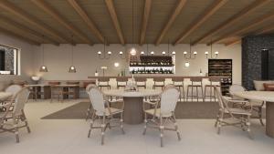 Un restaurante con mesas y sillas y un bar. en NĒRO Suites by NOMÉE Hospitality Group, en Imerovigli
