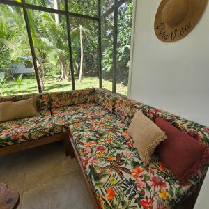 kanapę siedzącą w pokoju z dużym oknem w obiekcie La Rana De Cahuita w mieście Cahuita
