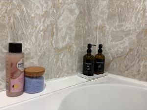 a bathroom with two bottles of soap and a bath tub at Lovely Holiday Home to explore beautiful West Wales in Carmarthen