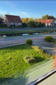 a view from a train window of a grassy field at Ferienwohnung Fehnzeit in Rhauderfehn