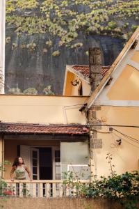 a woman standing on a balcony of a building at Chez Zany Boutique Hostel - Copacabana in Rio de Janeiro