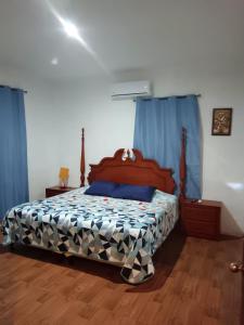 a bedroom with a bed with blue drapes at White House 1km Pradera in Chiquimula +24 photos