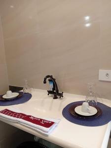 a kitchen counter with two plates and a sink at Kit com varanda in Sao Paulo