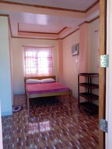 Habitación pequeña con cama y ventana en Pangga and Nanie Guest House, en Pooc