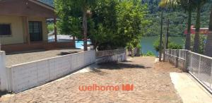 een huis met een hek rond een zwembad bij Casa em Chapeco com Piscina e Vista da Montanha in Nonoai