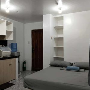 ein Schlafzimmer mit einem Bett und einem Waschbecken darin in der Unterkunft W Tramo Residences in Manila