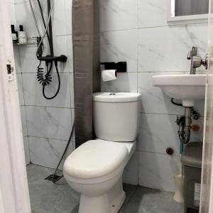 ein Badezimmer mit weißer Toilette und Waschbecken in der Unterkunft W Tramo Residences in Manila