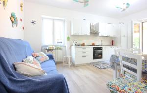 een woonkamer met een blauwe bank en een keuken bij Nice Apartment In San Marco Di Castellab in Castellabate