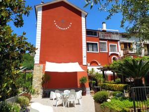 un edificio rojo con mesas y sillas blancas delante en Villa Elvira, en Pellezzano