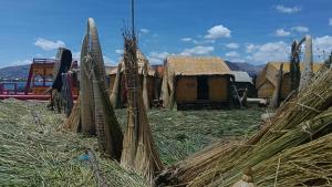 a group of buildings with hay and a fence at cabañas del inka in Puno