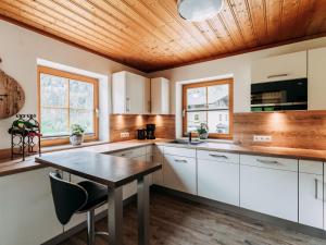 劳里斯Barney M的厨房配有白色橱柜和木质天花板 更多25张照片