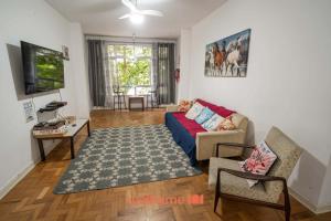ein Wohnzimmer mit Sofa und Tisch in der Unterkunft Apartamento no Guaruja 50m da Praia das Pitangueiras in Guarujá