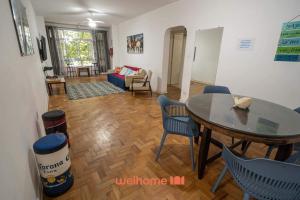 ein Wohnzimmer mit Tisch und Stühlen in der Unterkunft Apartamento no Guaruja 50m da Praia das Pitangueiras in Guarujá + 22 Fotos