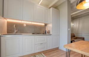 a kitchen with white cabinets and a table at Casa Persi in Gorleri