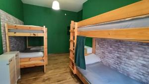 a room with two bunk beds and a green wall at Jopi Hostel Katowice Centrum in Katowice