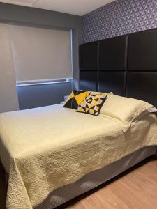 a bed with two pillows on it in a bedroom at Flat Pasargada 1016 Praia da Costa in Itaparica