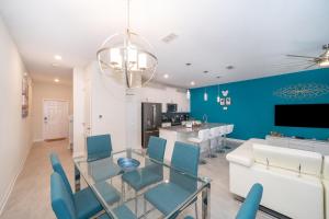 a dining room with a glass table and blue walls at 4830FA TOWNHOUSE 4 BEDROOMS & 3 BATHROOMS + POOL in Kissimmee