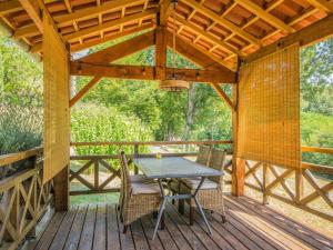 a wooden deck with a table and chairs on it at Mas dAmour in Montcabrier